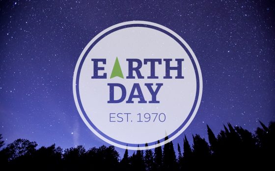 Earth Day badge over night sky