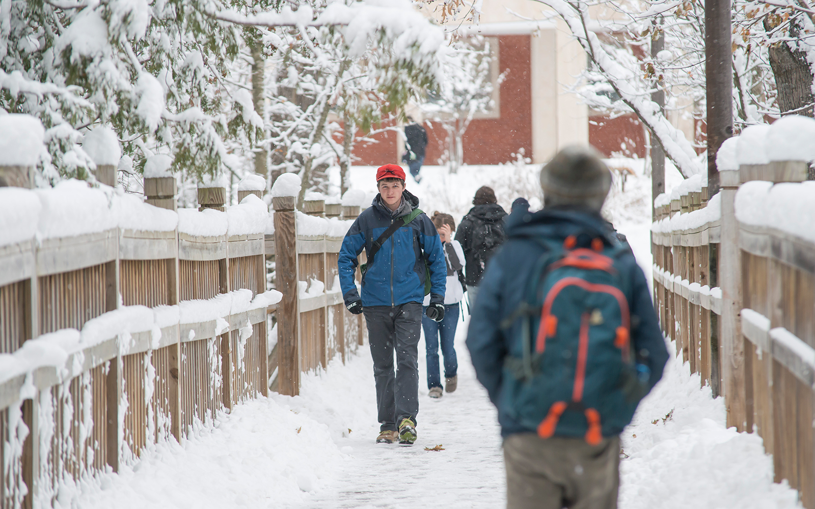 Students walking on bridge in winter.