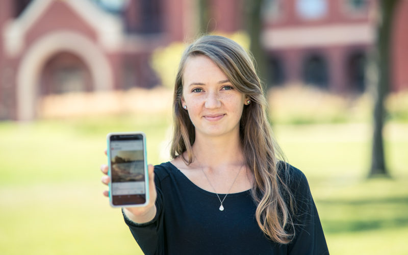 Northland College student holding phone.