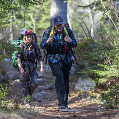 Students backpacking on a trail.