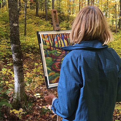 Northland College alum Terry Daulton painting in the woods