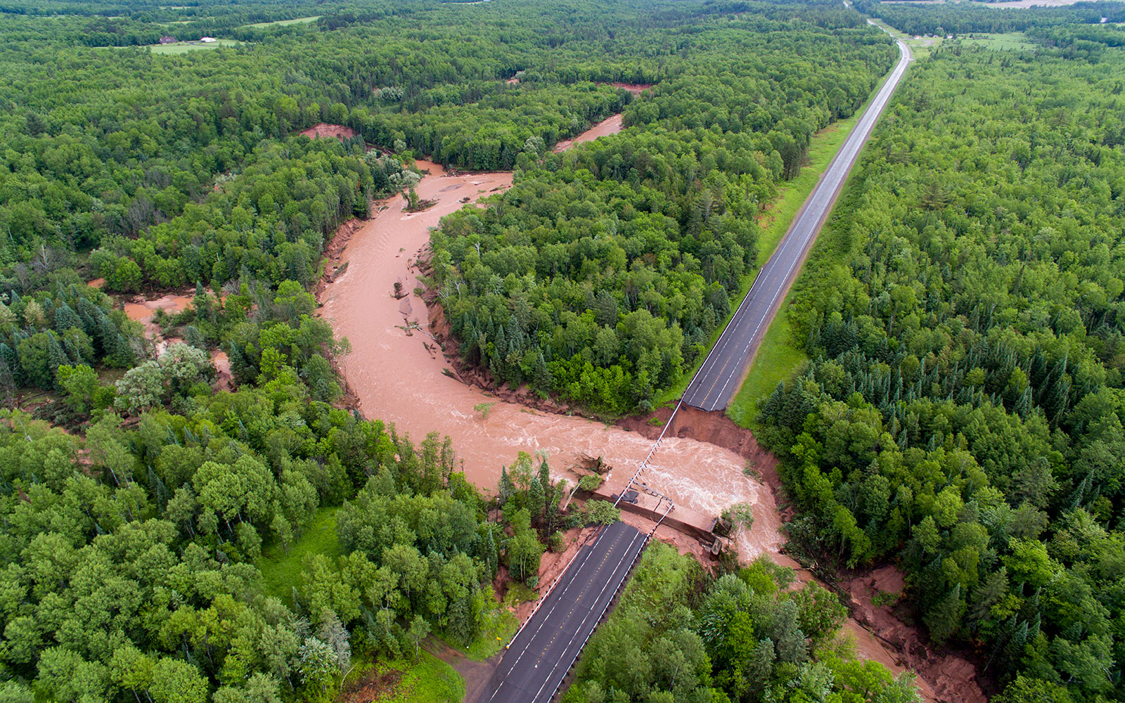 Aerial shot of river flowing through Highway 2, following June 2018 storm