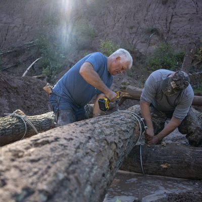 Two men binding logs to make a crib for a restoration project on North Fish Creek.