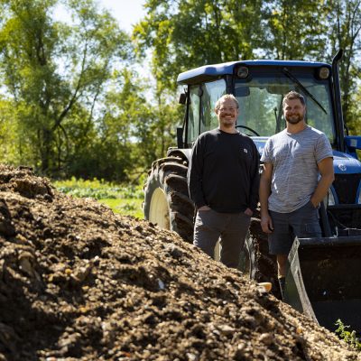 Big Lake Organics owners Jamie Tucker and Todd Rothe stand near compost pile.