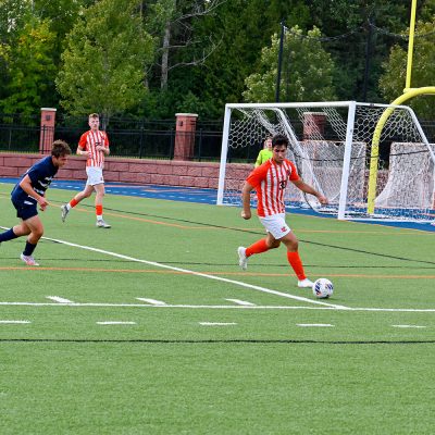 LumberJack athlete with a soccer ball during a game.