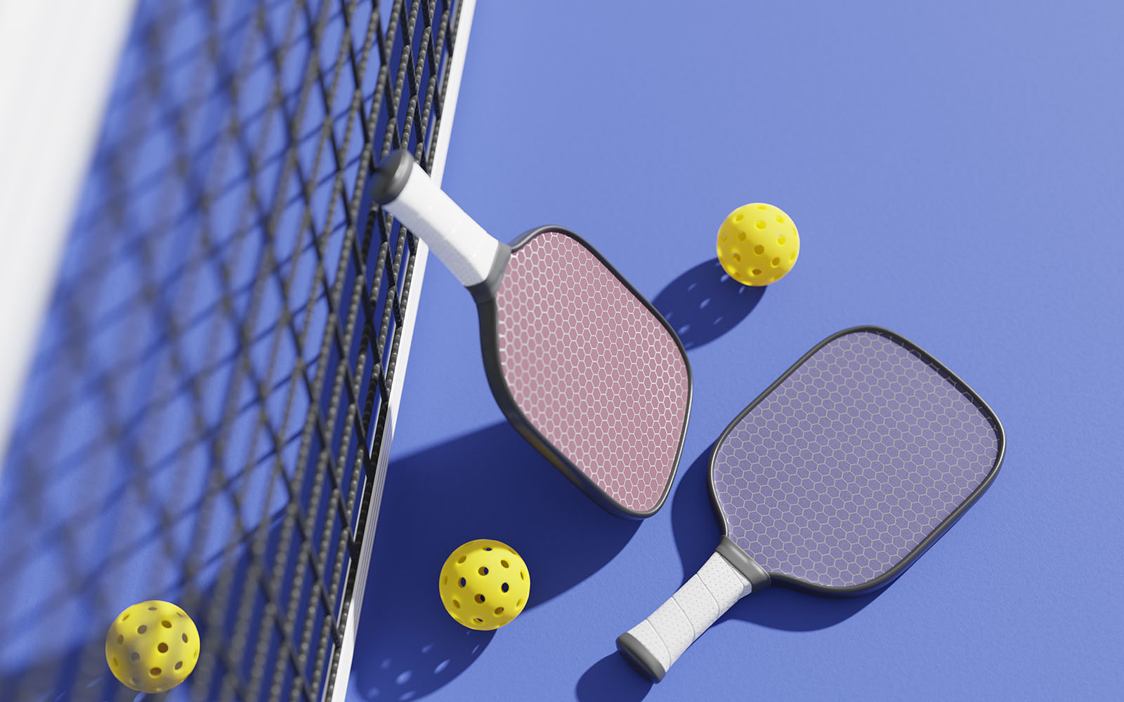 Pickleball paddles and balls alongside a net