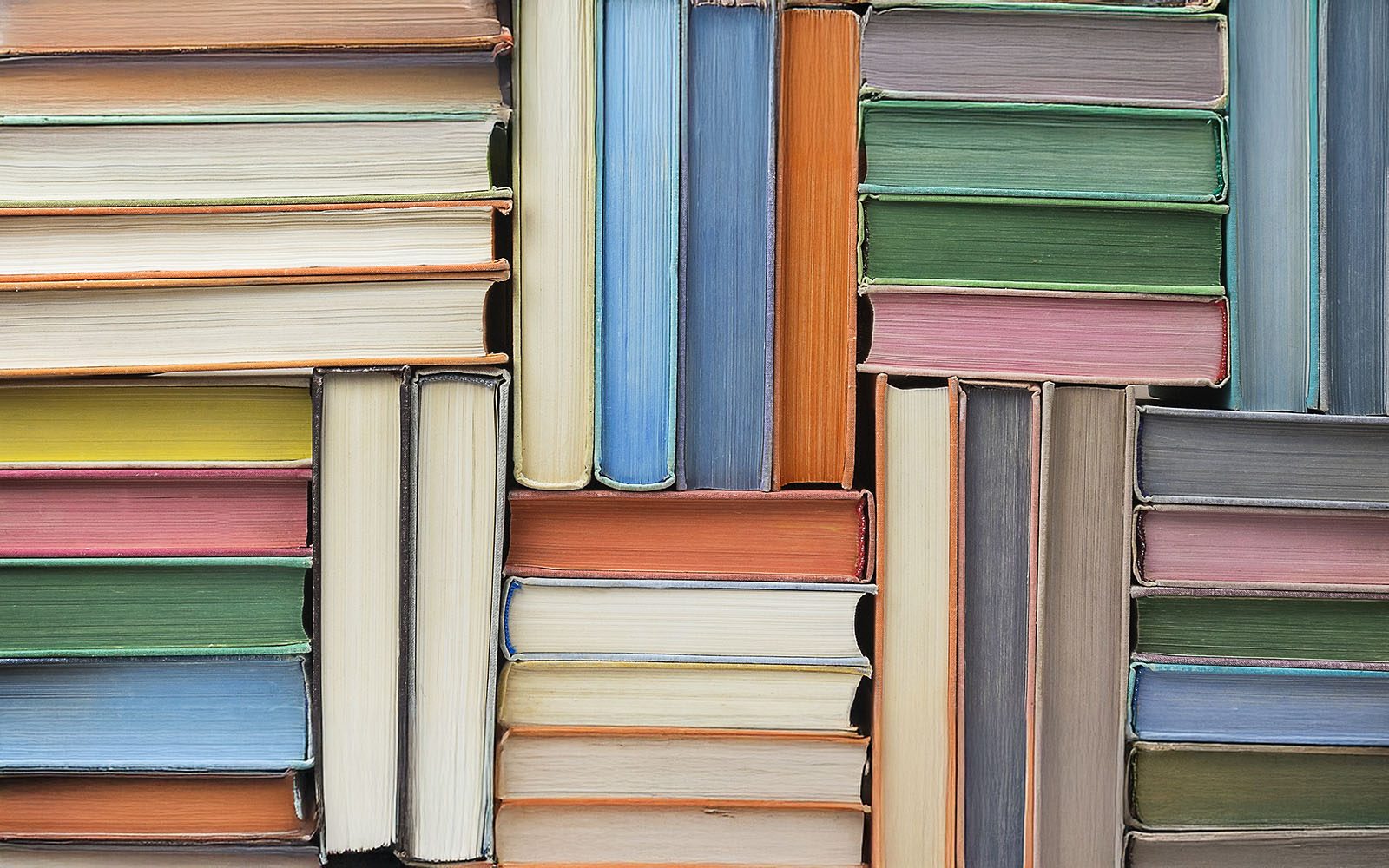Books stacked up on shelf.