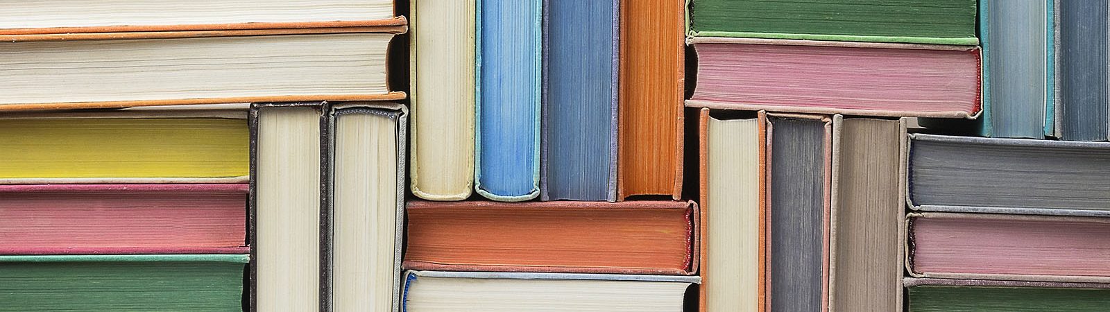 Books stacked up on shelf.